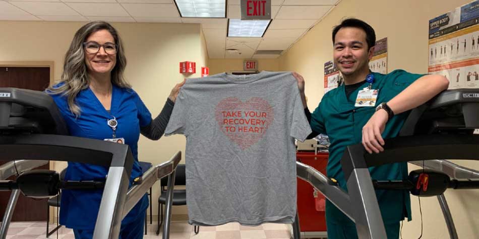 Two members of the MountainView cardiac rehab program hold a shirt that says, take your recovery to heart 